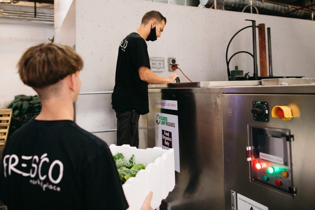 Fresco staff using the compost machine at Coffs Central