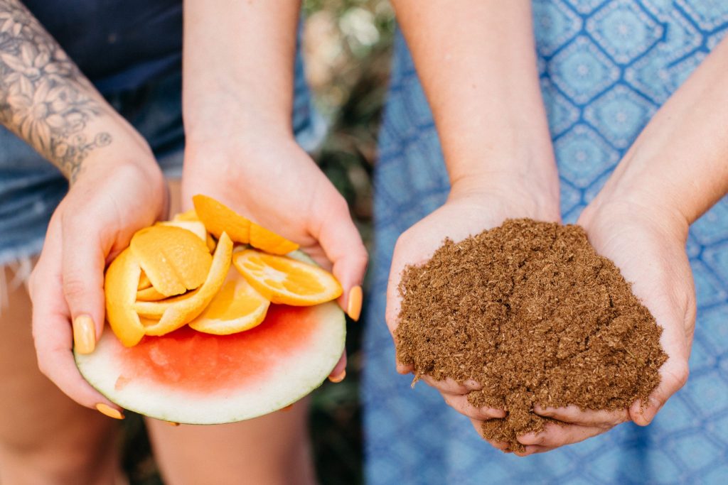 Hands holding fruit scraps and compost 