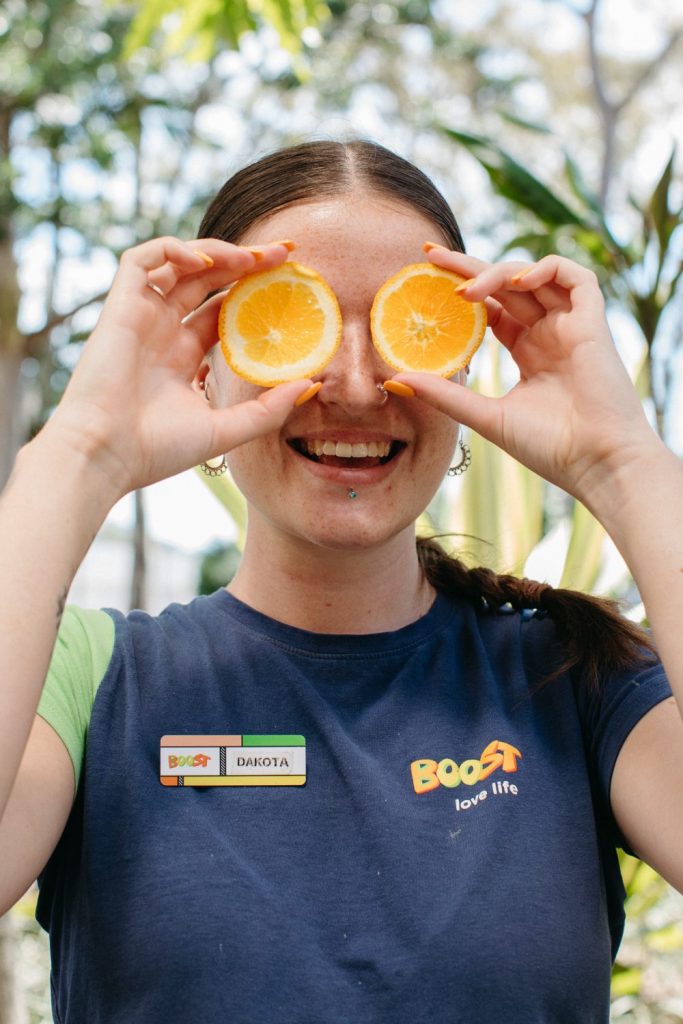 A young woman holds fruit scraps to put in the Coffs Central compost