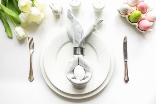 Easter table setting with white tulip on white table.